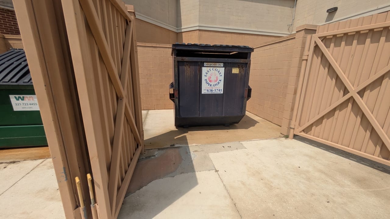 Freshly cleaned dumpster enclosure and concrete pad at Hammock Landing shopping plaza