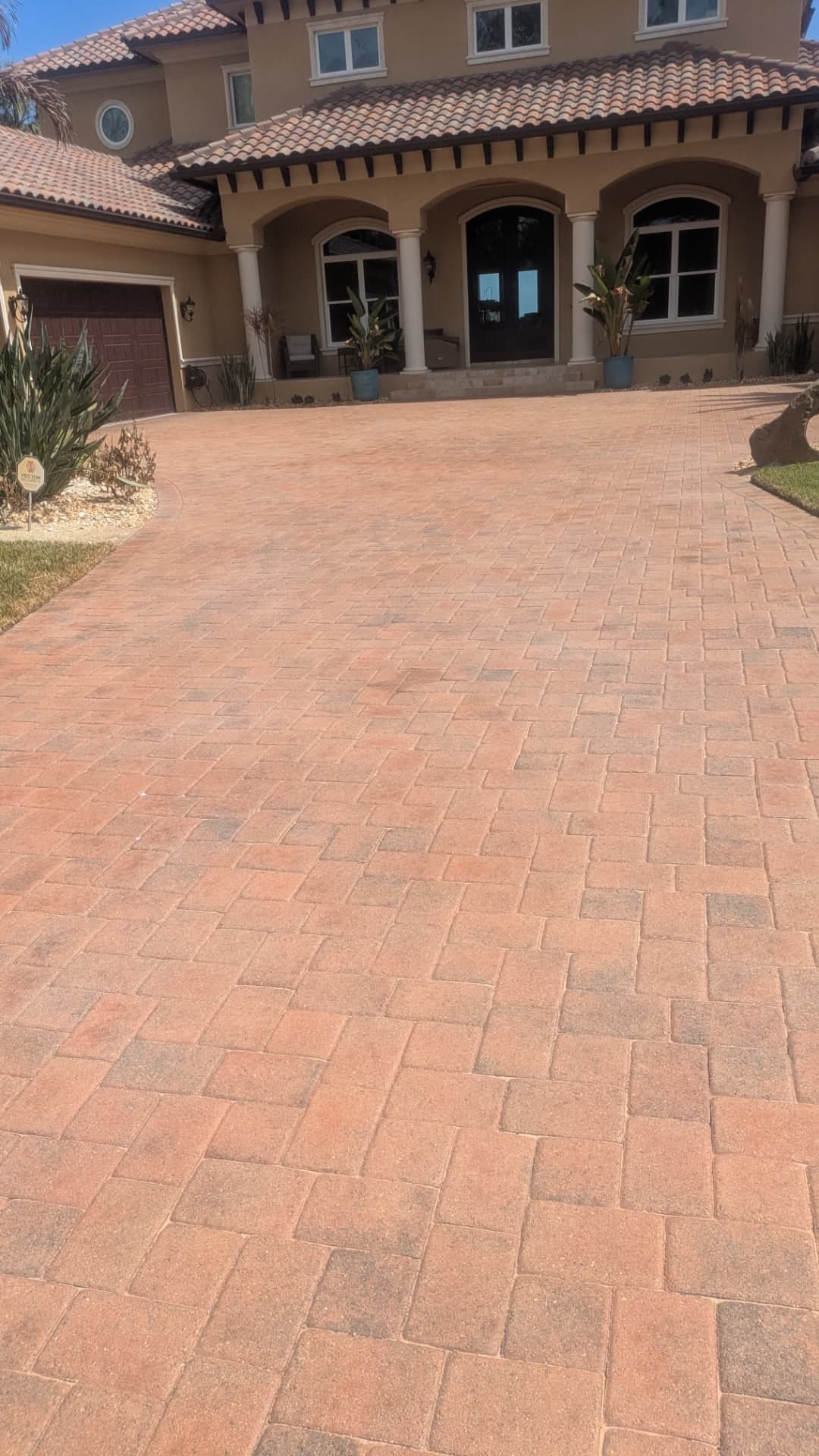 Multi-car brick paver driveway after cleaning, re-sanding, tinting, and sealing in Rockledge, FL