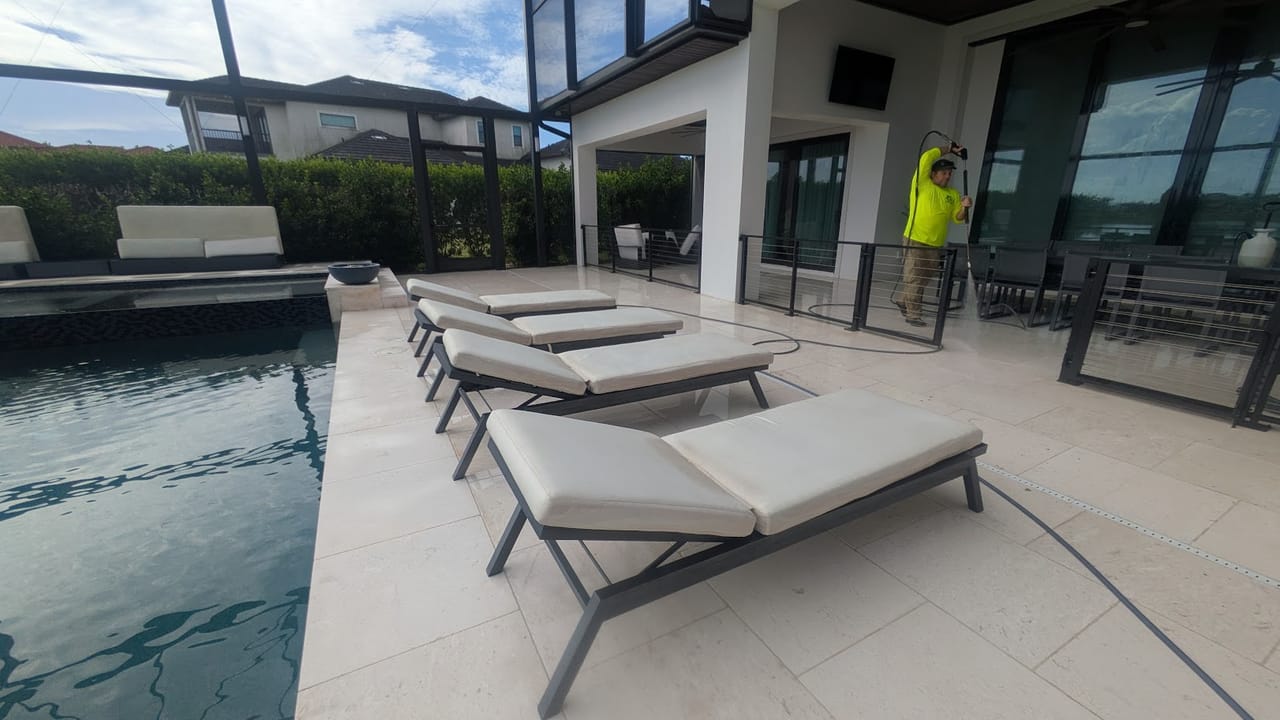 JPC crew member soft washing the pool enclosure and lanai of a lakefront home in Viera, FL
